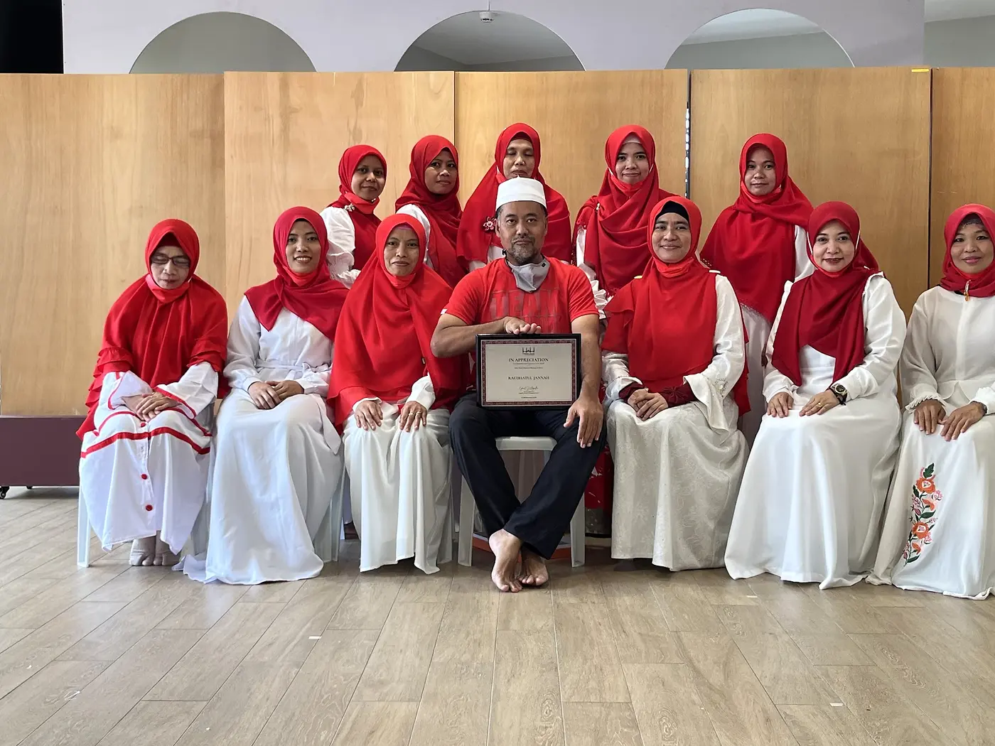 Members of the Al Maidah selawat ensemble dressed in red and white